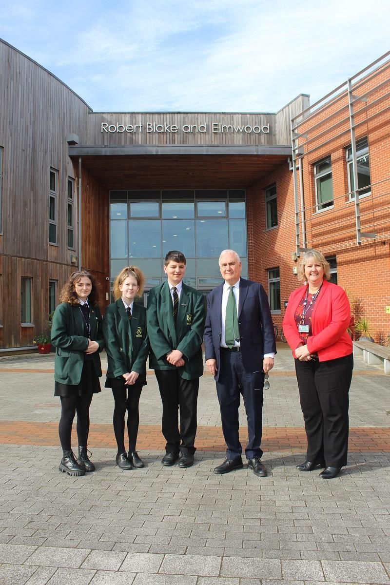 Sir Michael Wilshaw with three pupils and a member of staff outside Robert Blake and Elmwood school
